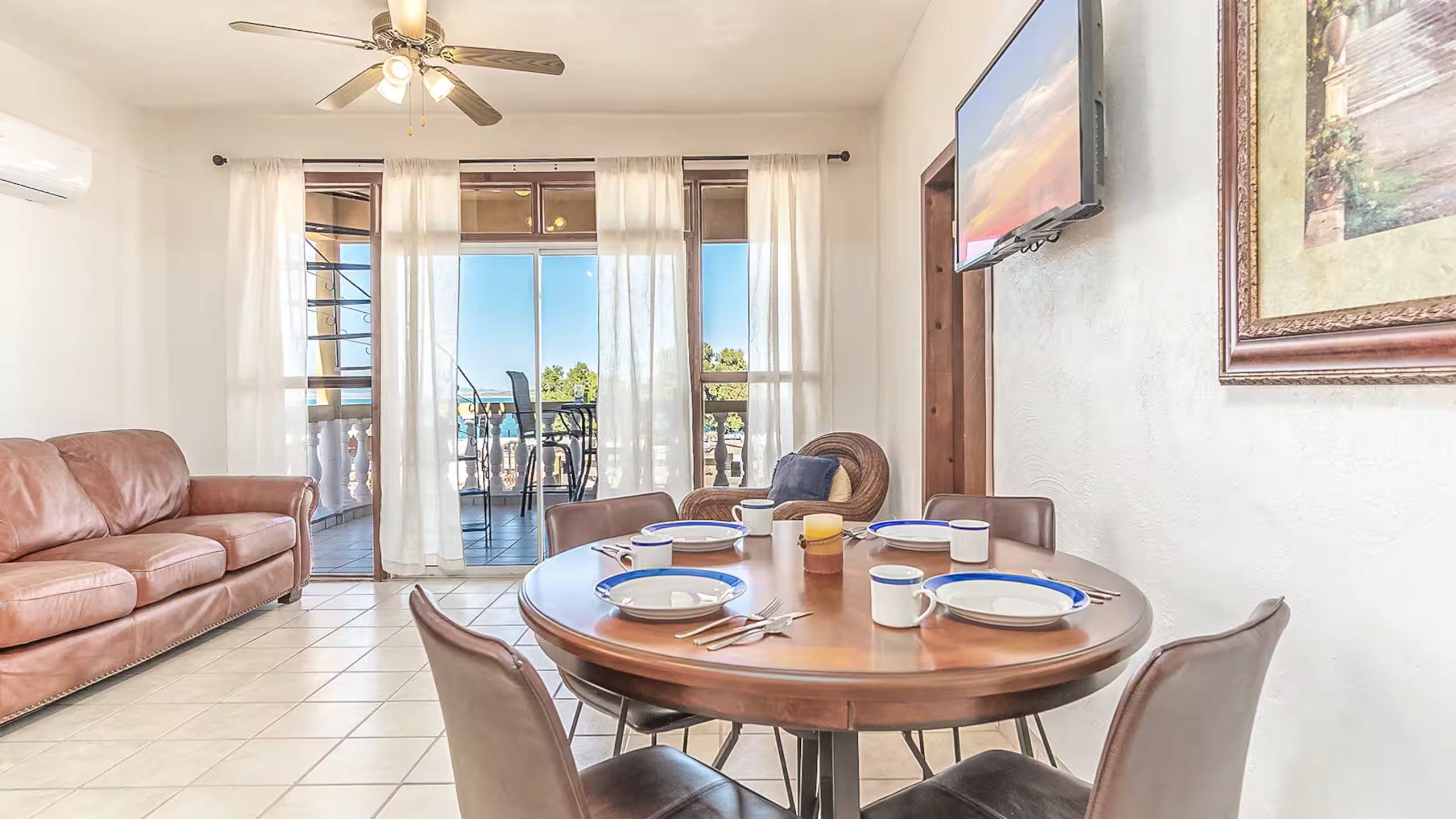 Round dining table for four beside the living room and balcony doors at Cholla Bay Vista