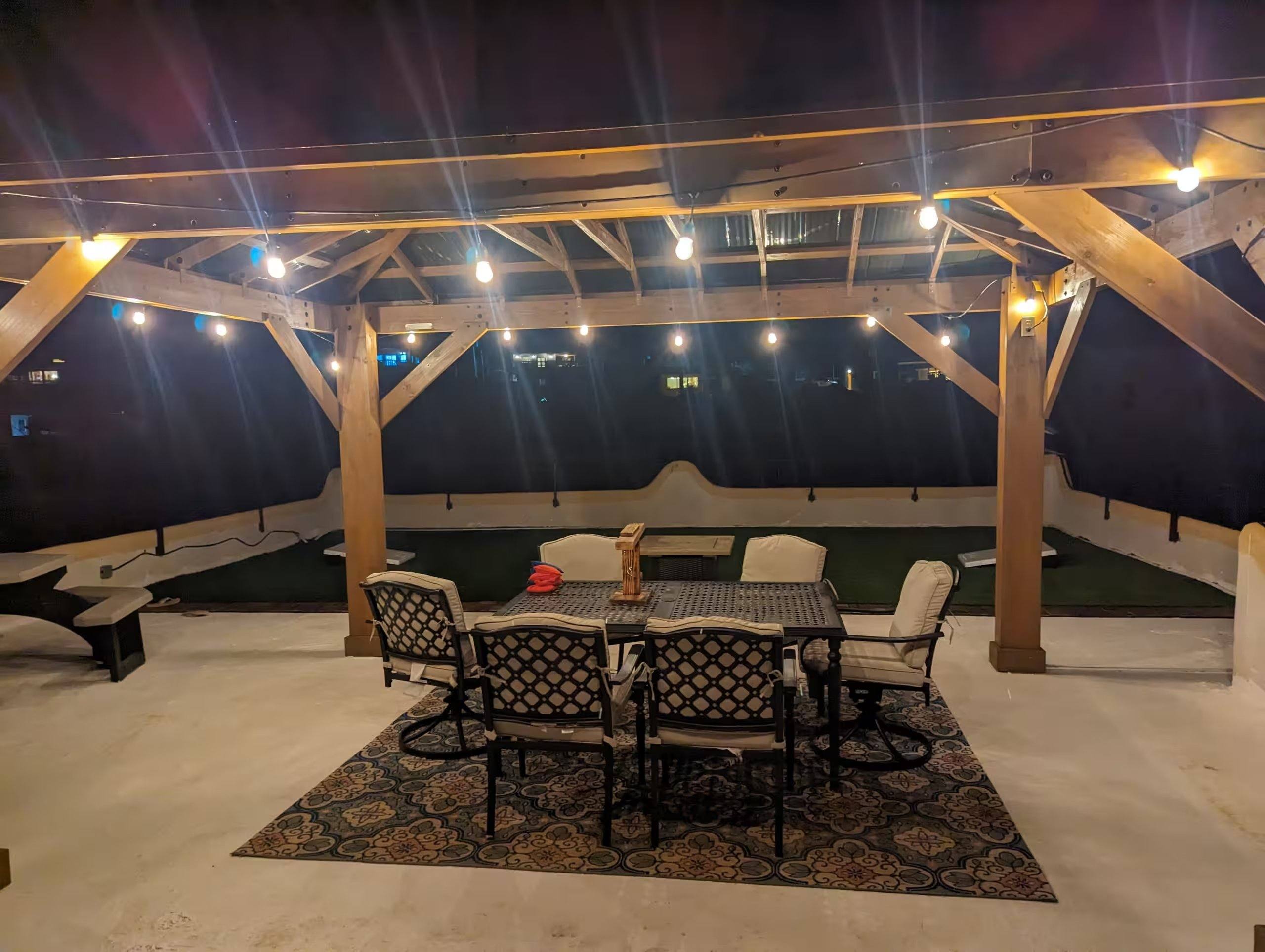 Rooftop palapa at Cholla Bay Vista lit with string lights at night over the outdoor dining table