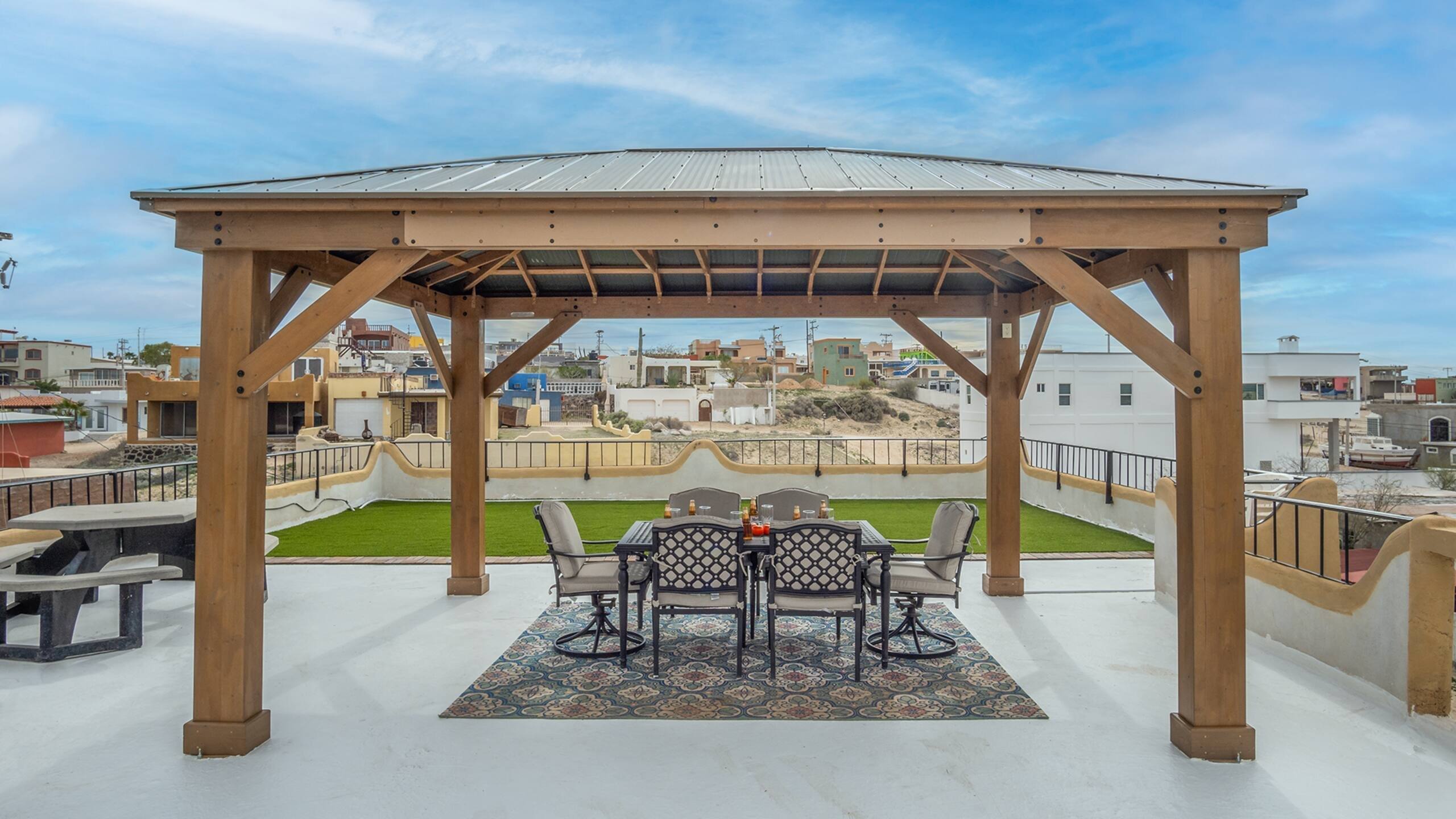 Rooftop palapa with a dining table and artificial turf lawn at Cholla Bay Vista