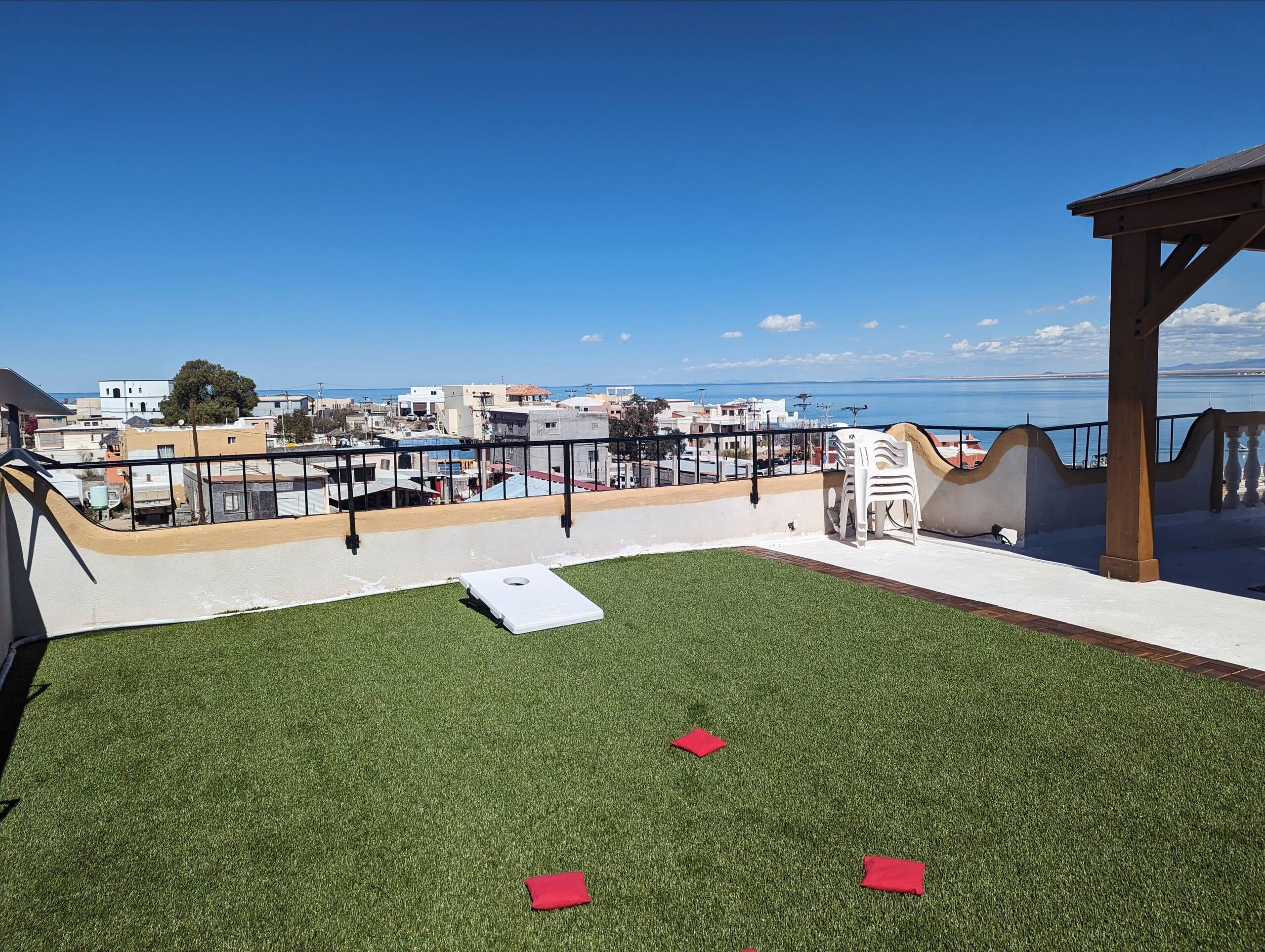 Cornhole boards on the rooftop turf at Cholla Bay Vista with a view across Cholla Bay